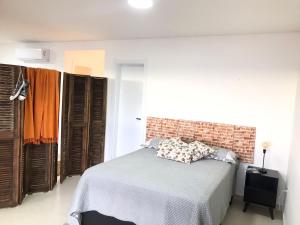 a bedroom with a bed and a brick wall at RESIDENCIAL Montevidéu 805 in Osório