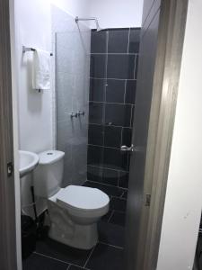 La salle de bains est pourvue de toilettes, d'un lavabo et d'une douche. dans l'établissement Aparta estudio amoblado 3 Medellin, San joaquin, à Medellín