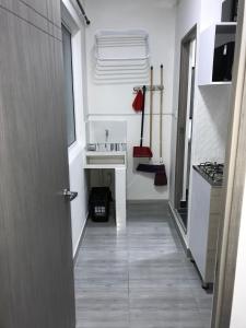 um corredor que leva a uma cozinha com um lavatório em Aparta estudio amoblado 3 Medellin, San joaquin em Medellín