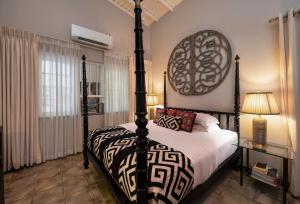 a bedroom with a bed with a black and white bedspread at 55TG Boutique Suites in Colombo