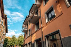 un edificio alto de color naranja con balcones en una calle en Amiata Suite en Abbadia San Salvatore