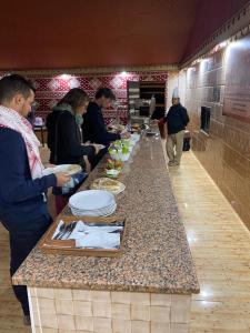 a group of people standing at a buffet line with food at Rum Stars Camp in Wadi Rum