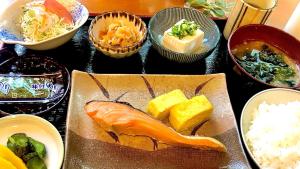 uma mesa coberta com pratos de comida e tigelas de comida em Hotel Shin Osaka em Osaka