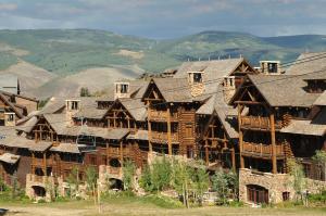 a large log cabin building with mountains in the background at Snowlcoud 203 condo in Avon
