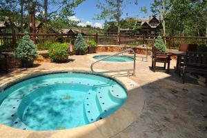 a hot tub in a yard with a table and chairs at Snowlcoud 203 condo in Avon