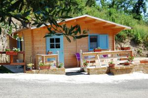 a small wooden cabin with a porch and a door at Agriturismo Poggiocolone in Tuscania