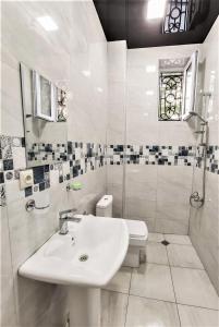 Baño blanco con lavabo y aseo en Mango's Guesthouse en Kutaisi