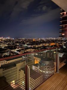 Blick auf die Stadt in der Nacht von einem Gebäude in der Unterkunft Triiiple Suites Level 22 mit Balkon und Tiefgarage in Wien
