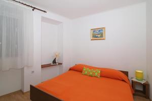 a bedroom with a bed with an orange blanket at Dubrovnik Heritage Apartments in Dubrovnik