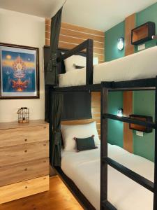 a bedroom with two bunk beds and a dresser at My Bunk Hostel in Ko Samed