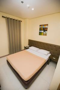 a bedroom with a large bed with a headboard at Hotel 801 in Cagayan de Oro