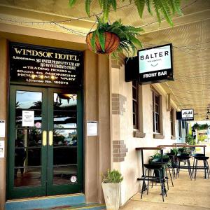 Windsor Hotel Miles في Miles: باب امام مطعم به طاولات وكراسي