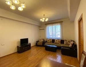 uma sala de estar com um sofá e uma televisão em Argishti street 2 bedroom Elegance apartment with balcony GL152 em Yerevan