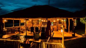 a wooden cabin with chairs and an umbrella at night at Vintage Cottage in Rwamagana