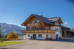 a large house with a wooden roof at Deluxe Appartement Blasbichlerhof in Ramsau am Dachstein