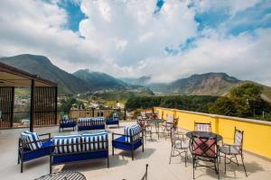 a patio with chairs and tables with mountains in the background at Mount Inn Kazbegi in Kazbegi
