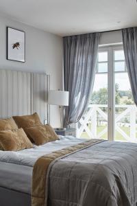 a bedroom with a bed and a large window at Farma Bii in Brzeziny