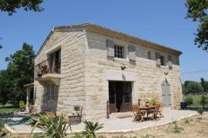 a stone house with a table in front of it at Le Mazet De Jean in Le Cailar