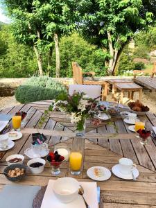 - une table en bois avec de la nourriture et des boissons dans l'établissement La Maison d'Alice, à Vézac