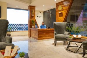 una mujer en una sala de espera con sillas y una mesa en Coral Reef Hotel & Spa, Port Blair, en Port Blair