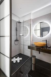 uma casa de banho com um lavatório e uma cabina de duche em vidro. em Hotel Poerio 25 Boutique Stay em Nápoles