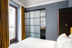 um quarto com uma cama branca e uma casa de banho em Hotel Poerio 25 Boutique Stay em Nápoles