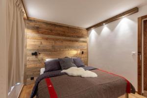a bedroom with a bed with a wooden wall at Apartment Etrier in Crans-Montana +7 photos