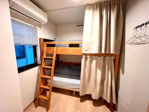Nara Deer Hostel- - 外国人向け - 日本人予約不可 في نارا: غرفة صغيرة مع سرير بطابقين وسلم