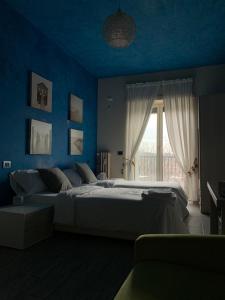 a blue bedroom with a large bed and a window at Stileroma in Rome