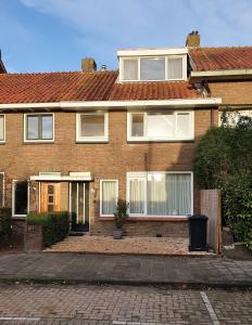 a brick house with white windows and a driveway at Single family home in Hillegersberg - Schiebroek in Rotterdam