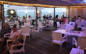 a group of people sitting at tables in a restaurant at M8 Umdloti Holiday Resort in Umdloti