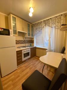 una cucina con un frigorifero bianco e un tavolo di 2 комнатная квартира, до 6 спальных мест(КБ-75,Ашан, Метро,Эпицентр) a Kryvyj Rih