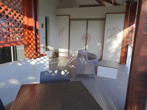 a rendering of a room with chairs and a table at Pension Tiputa Lodge Rangiroa in Tiputa