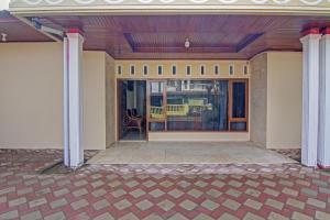 a porch of a house with two columns at Super OYO Capital O 90643 Suri Guest House Syariah in Padang