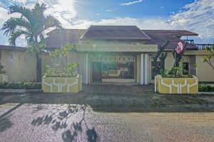 a house with a palm tree in front of it at Capital O 90643 Suri Guest House Syariah in Padang