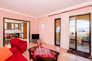 un soggiorno con divano rosso e tavolo di Guesthouse Somnium a Cavtat