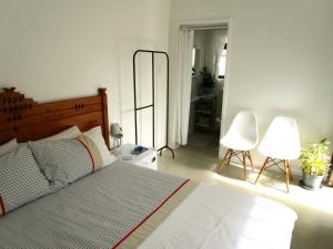 a bedroom with a bed and two chairs and a mirror at Sherwood Garden in Cape Town