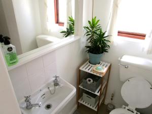 a bathroom with a tub and a toilet and a sink at Sherwood Garden in Cape Town
