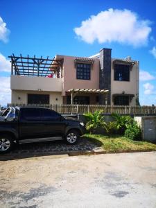 een zwarte truck geparkeerd voor een huis bij 2 bedrooms villa with sea view private pool and enclosed garden at Bel Ombre 1 km away from the beach in Bel Ombre
