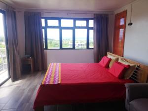 a bedroom with a red bed with a large window at Elegant villa with sea view in Bel Ombre + Private pool in Bel Ombre +12 photos