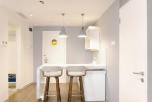 a kitchen with two stools at a kitchen counter at Yello Hotel Jambi in Jambi