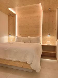 1 dormitorio con 1 cama grande y cabecero de madera en Eurochalet en Campitello di Fassa