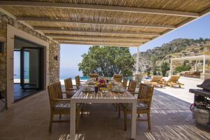 a dining room with a table and a view of the ocean at Infinity Alinca in Karaagac