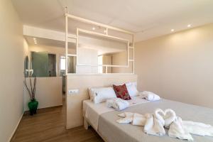 a bedroom with a bed with towels on it at Belussi Beach Hotel & Suites in Kypseli