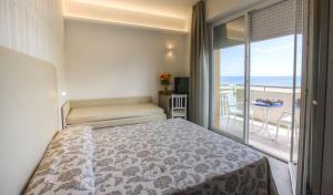 Hotel 2000 في ريميني: غرفة نوم مع سرير وشرفه مع المحيط