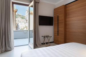 a bedroom with a large bed and a large window at Hotel Poerio 25 Boutique Stay in Naples