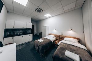 ein Zimmer mit zwei Betten und einer Küche darin in der Unterkunft Apartamenty EXPO Nadarzyn 3Rooms in Kajetany