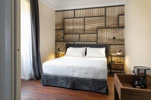 a bedroom with a white bed and a wooden floor at Hotel Poerio 25 Boutique Stay in Naples