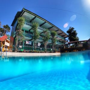 a building with a swimming pool in front of it at Lucena Fresh Air Hotel in Lucena
