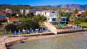 KypseliにあるBelussi Beach Hotel & Suitesのビーチでの椅子とパラソル付きのリゾート